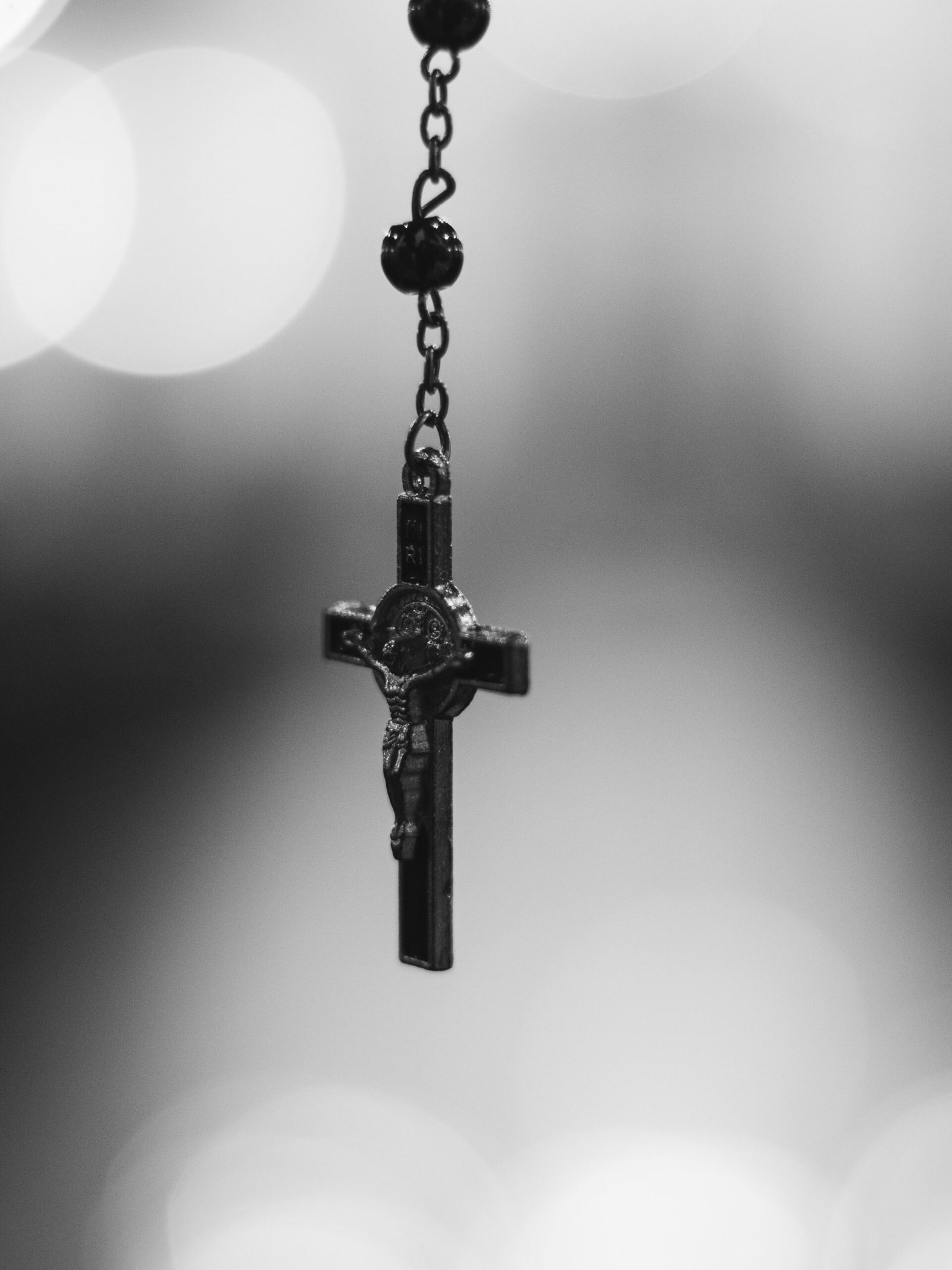 Detailed black and white image of a rosary cross symbolizing faith and spirituality.